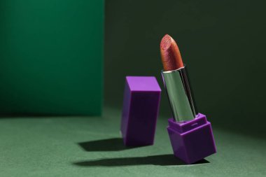 Yeşil arka planda güzel ruj izi olan kompozisyon, yakın plan.