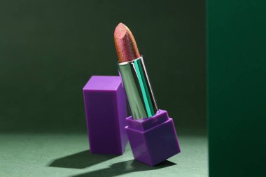 Yeşil arka planda güzel ruj izi olan kompozisyon, yakın plan.