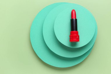 Yeşil arka planda güzel kırmızı ruj ve alçı podyumlar, yakın plan.