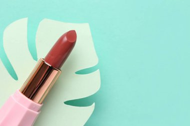 Yeşil arka planda yaprak şeklinde güzel ruj ve alçı podyum, yakın plan.