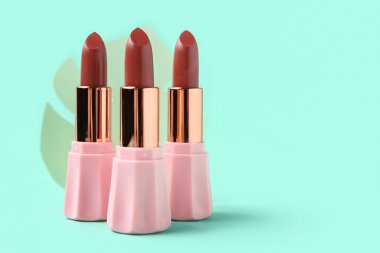 Yeşil arka planda güzel ruj izleri olan kompozisyon, yakın plan.