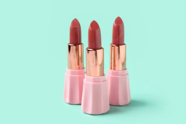 Yeşil arka planda güzel ruj izleri olan kompozisyon, yakın plan.