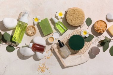 Bej rengi grunge arka planda kozmetik ürünleri, spa taşları ve deniz tuzu içeren kompozisyon