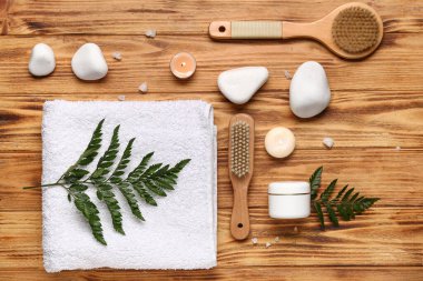 Spa taşları, kozmetik ürünler ve ahşap arka planda banyo aksesuarları olan kompozisyon