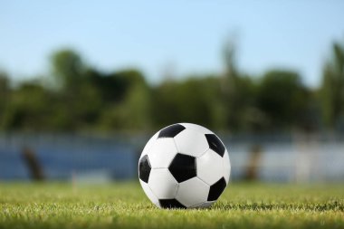 Yeşil stadyum çimlerinde futbol topu, yakın plan.