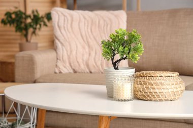 Hasır kutu, mum ve çiçek odadaki masada, yakın plan.