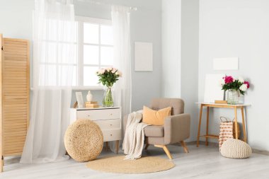 Gri koltuklu, kostümlü ve güzel şakayıklı şık bir oturma odası.