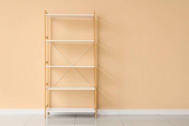 Bej duvarın yanında boş beyaz kitaplık