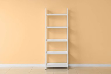 Bej duvarın yanında boş beyaz kitaplık