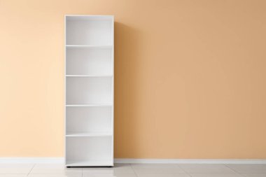 Bej duvarın yanında boş beyaz kitaplık