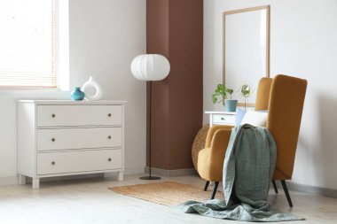 Rahat koltuğu ve beyaz çekmeceleri olan şık bir oturma odası.