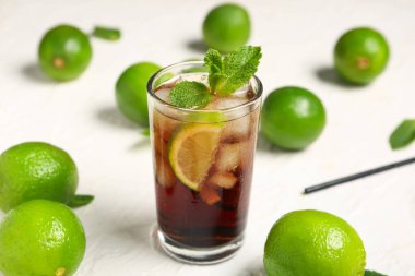 Beyaz arka planda naneli ve limonlu soğuk Küba Libre kokteyli.