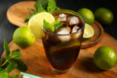 Siyah arka planda naneli ve limonlu soğuk Küba Libre kokteyli.