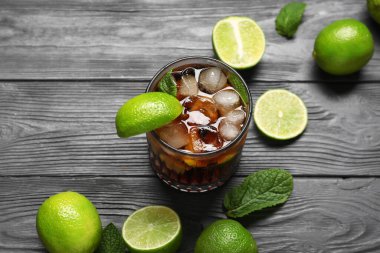 Siyah ahşap arka planda naneli ve limonlu soğuk Küba Libre kokteyli
