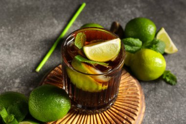 Gri arka planda naneli ve limonlu soğuk Küba Libre kokteyli.