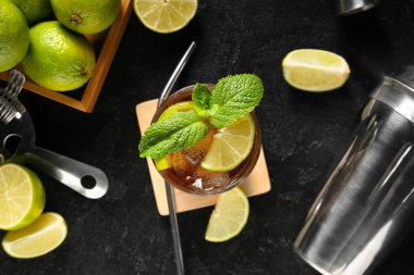 Soğuk Küba kokteyli ve siyah arka planda limonlu ahşap kutu.