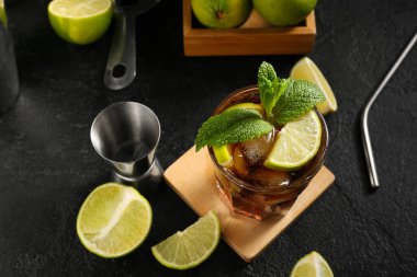 Siyah arka planda naneli ve limonlu soğuk Küba Libre kokteyli.