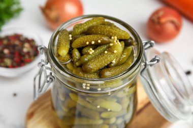 Beyaz arka planda lezzetli salatalıklı kavanoz, yakın plan.