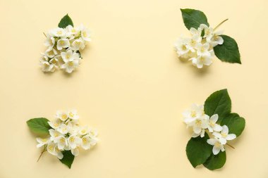 Güzel yasemin çiçeklerinden yapılmış çerçeve ve sarı arkaplanda yapraklar