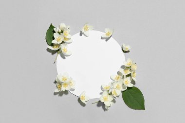 Gri arkaplanda yasemin çiçekleri olan boş bir kart.