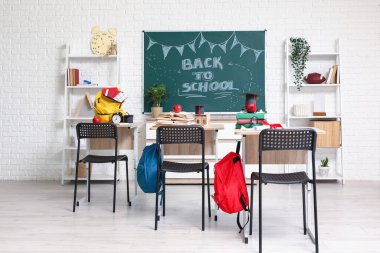 Okul sıraları, raf üniteleri ve karatahtayla dolu boş sınıfın içi