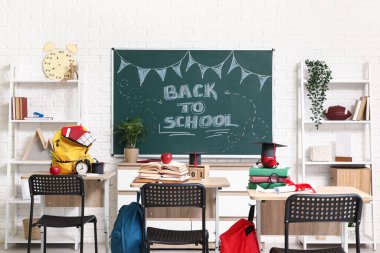 Okul sıraları, raf üniteleri ve karatahtayla dolu boş sınıfın içi