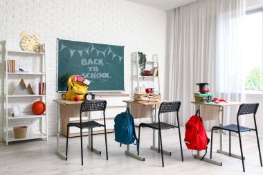 Okul sıraları, raf üniteleri ve karatahtayla dolu boş sınıfın içi