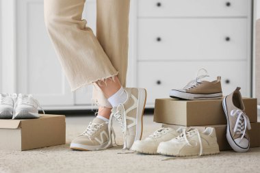 Genç kadın evde yeni hafif ayakkabılar seçiyor.
