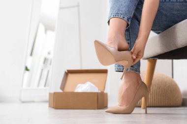 Genç bir kadın yeni yüksek topuklu ayakkabılar deniyor.