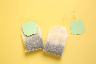 Sarı arkaplanda çay poşetleri, yakın plan.