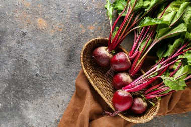 Gri grunge arka planında taze pancar kökleri olan hasır sepet.
