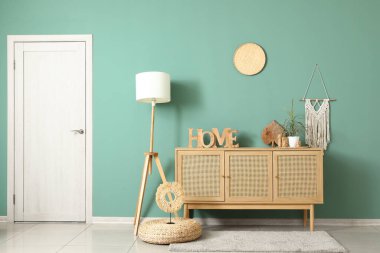 Çekmeceler, puf ve zemin lambası, odanın içindeki yeşil duvarın yanında.