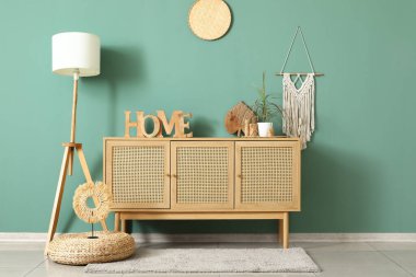 Çekmeceler, puf ve zemin lambası, odanın içindeki yeşil duvarın yanında.