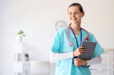 Klinikte not defteri olan bir kadın stajyer.