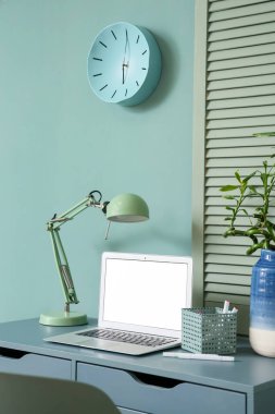 Modern dizüstü bilgisayarı ve lambası olan rahat bir iş yeri.
