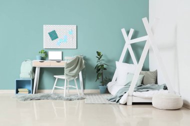 Rahat yatağı, masası ve sandalyesi olan çocuk odası.