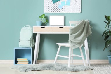 Naneli duvarın yanında masa ve sandalye olan çocuk odasının içi, yakın plan.