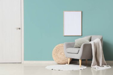 Oturma odasının içinde rahat bir koltuk ve nane duvarının yanında puf.