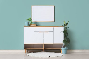 Oturma odasının iç tarafındaki nane duvarının yanındaki çekmeceler ve bitkiler.