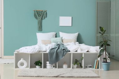 Yatak odasının içi, büyük rahat yatak, katlanabilir ekran ve raf ünitesi.