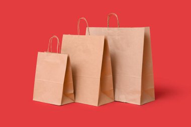 Kırmızı arka planda kağıt alışveriş torbaları