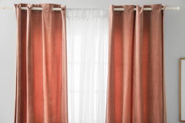 Işık odasında asılı pembe ve beyaz perdeler