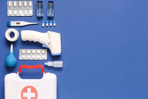 Комплект первой помощи и различные медикаменты на синем фоне
