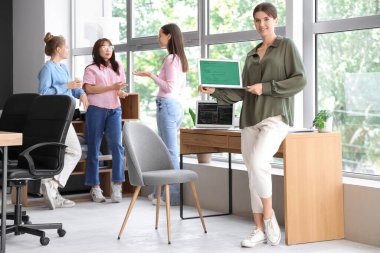 Ofisinde dizüstü bilgisayarı olan kadın programcı