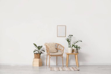 Koltuğu, masası ve yeşil bitkileri olan ışık odasının içi