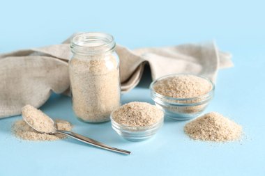 Kavanoz ve kaseler mavi arka planda psyllium kabuk pudrası ile