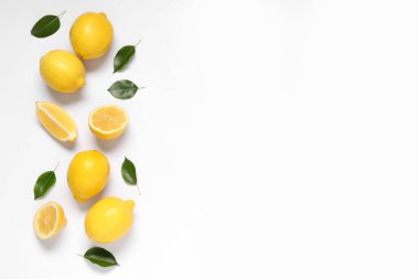 Taze olgun limonlar ve gri arka planda yapraklar