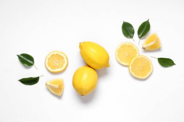 Taze olgun limonlar ve gri arka planda yapraklar