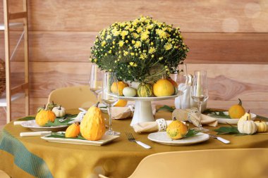 Yemek odasında çiçekler ve balkabaklarıyla sonbahar masası.