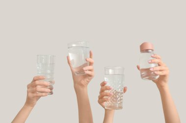 Şişeli kadın elleri ve arka planda soğuk su bardakları.